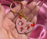 Gold plated pink heart with red horns with a face , sticking tongue out enamel keychain 
