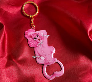 Metal keychain with gold key ring of a sexy pink poodle woman looking back. She has corset piercing on her back. The bottom is a bottle opener