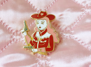 Gold plated pink and red cowgirl wielding pistols enamel pin