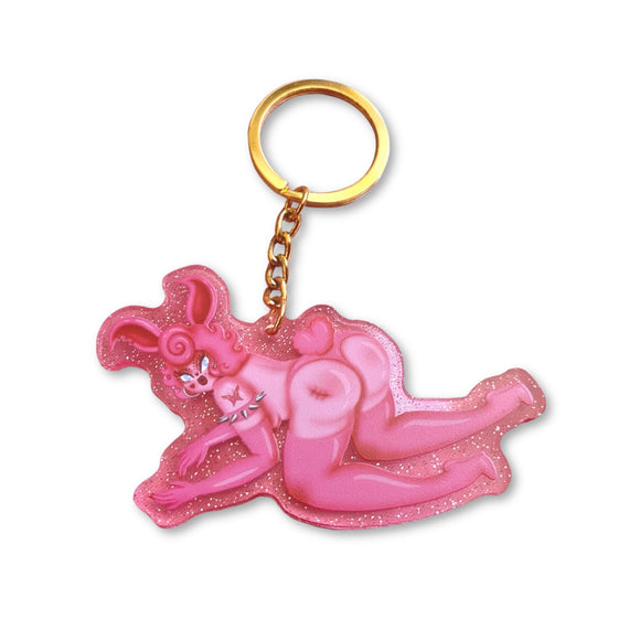 Pink clear glitter acrylic keychain with gold key ring featuring a sexy pink rabbit character named Rhonda Rabbit posing on her hands and knees looking cute