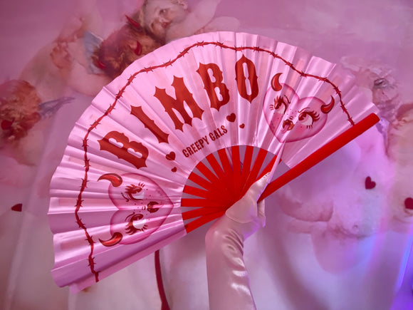 Pink and red Hand fan with the word Bimbo in the center with devil hearts on each side of the text. Band I’d red Barbwire on top