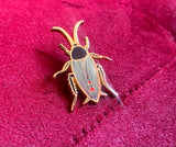 Gold plated cute black cockroach with red hearts enamel pin.