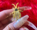 Gold plated cute black cockroach with red hearts enamel pin.